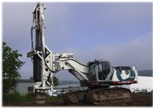 Der New Holland Raupenbagger E 485B ist mit einem dreiteiligen Kontergewicht und einem auf drei Meter Spurbreite teleskopierbaren Unterwagen modifiziert.